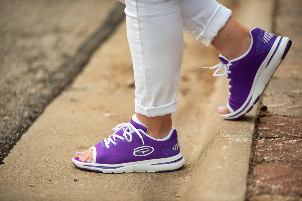 Woman in white pants walking in purple OpeToz open-toe athletic shoes